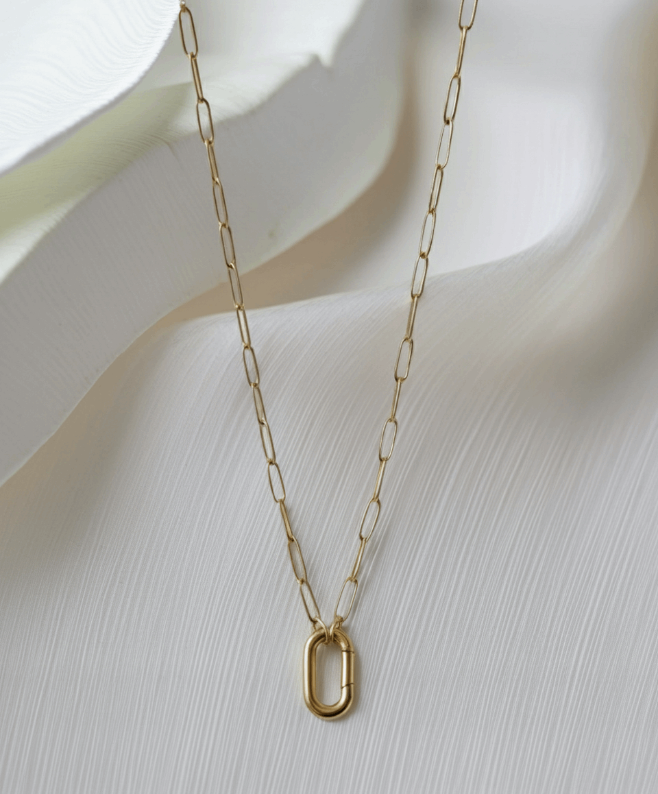 Gold chain necklace with a small pendant on a white background