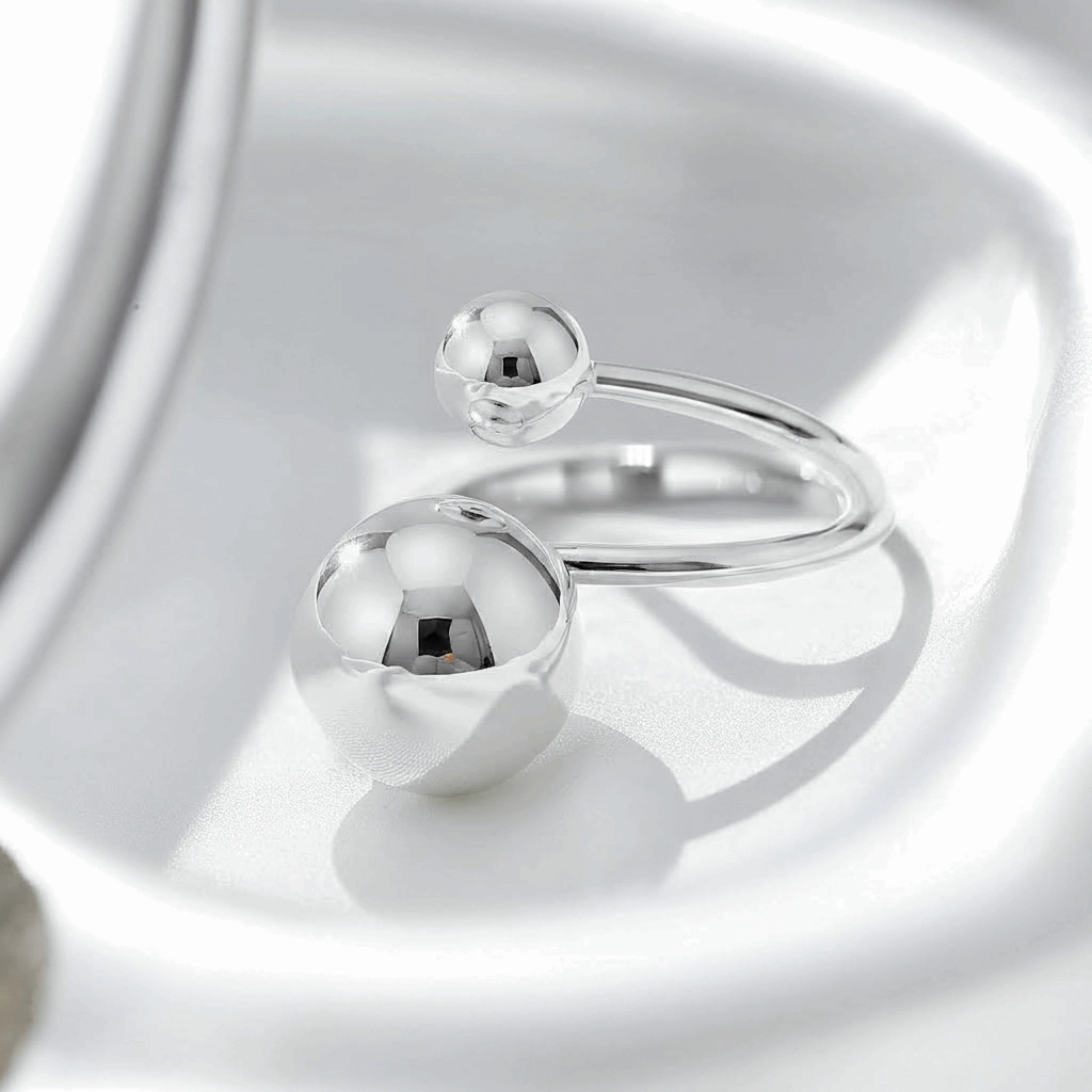 Silver ring with spherical elements on a reflective surface