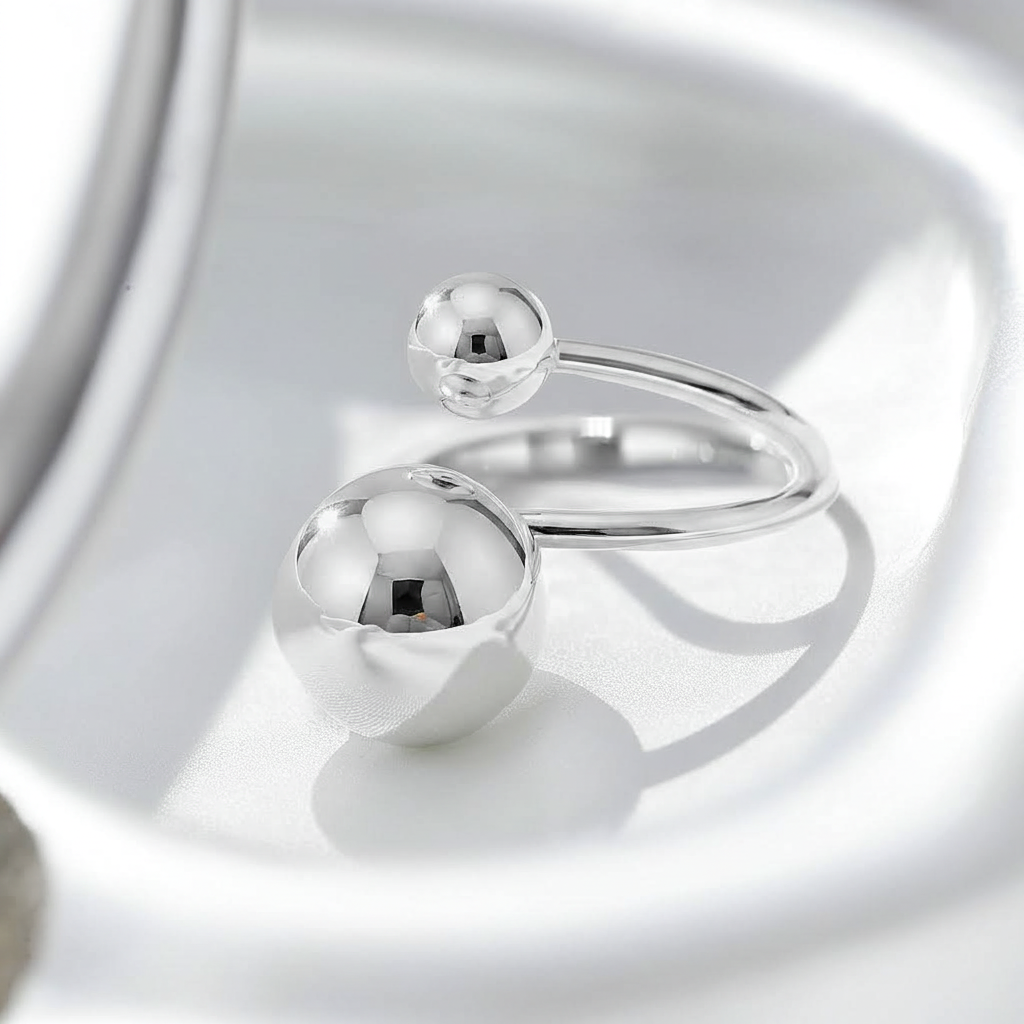 Silver ring with spherical elements on a reflective surface