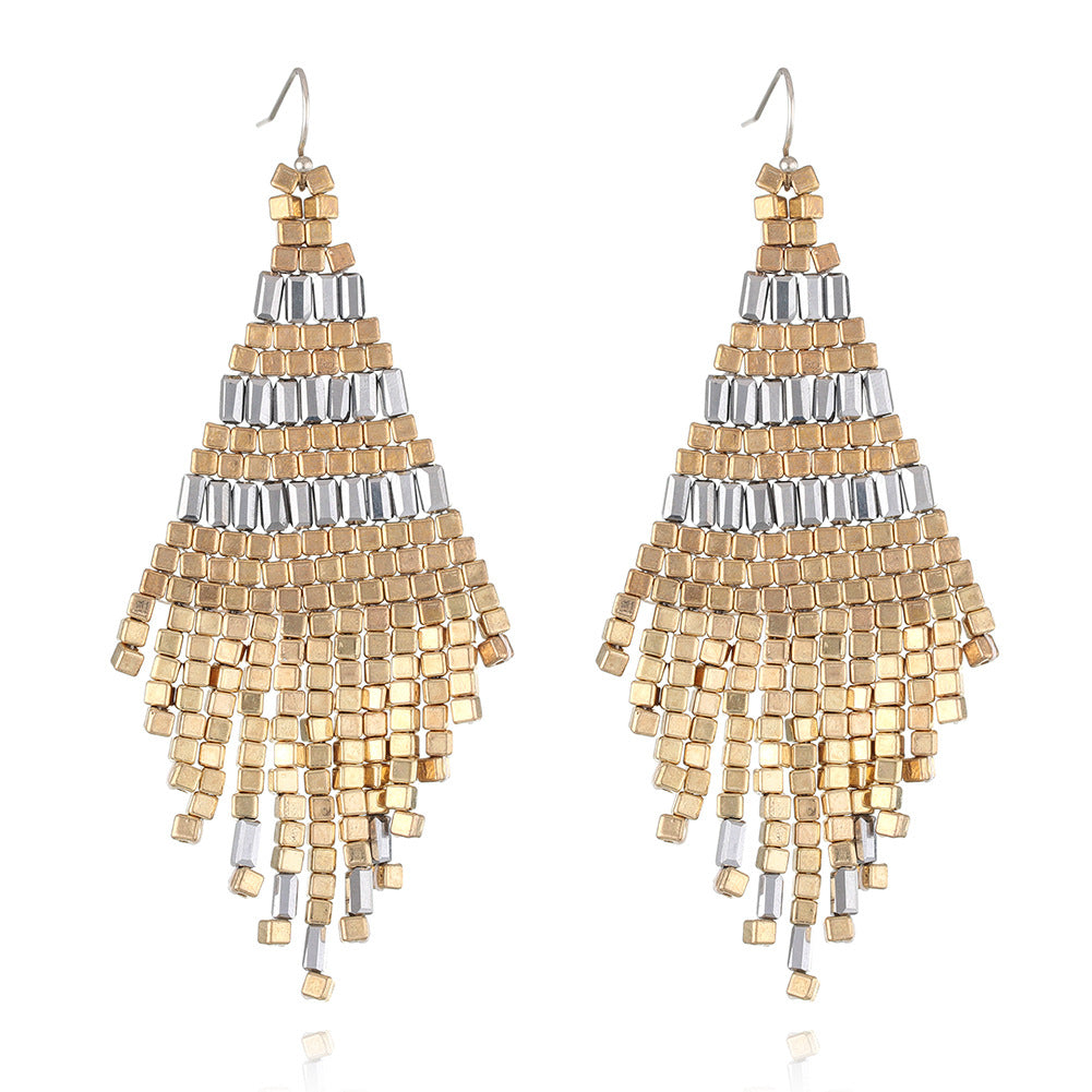 Pair of gold and silver beaded earrings on a white background
