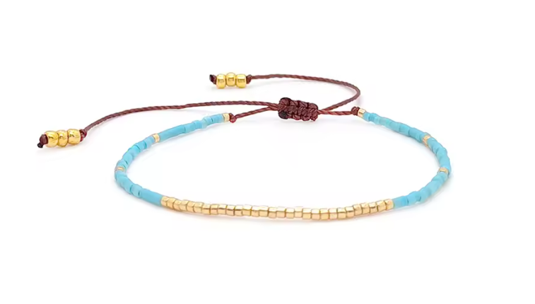 Bracelet with blue and gold beads on a white background