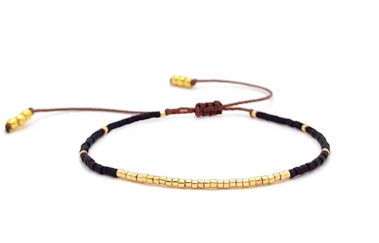 Black and gold beaded bracelet on a white background