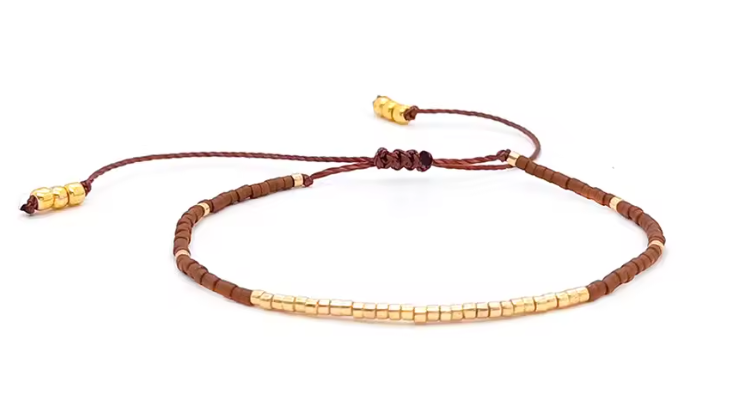 Bracelet with brown and gold beads on a white background