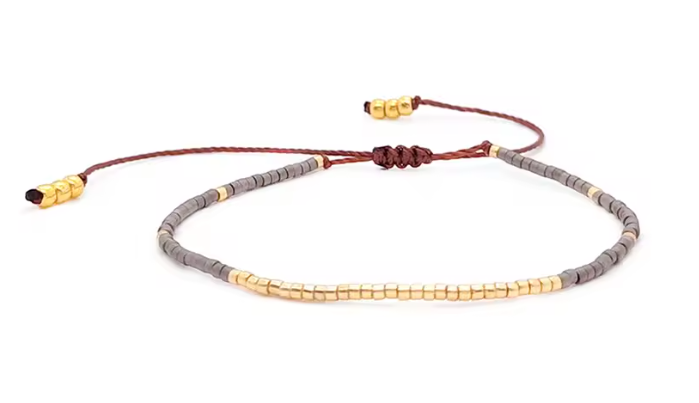 Bracelet with gray beads and gold accents on a white background