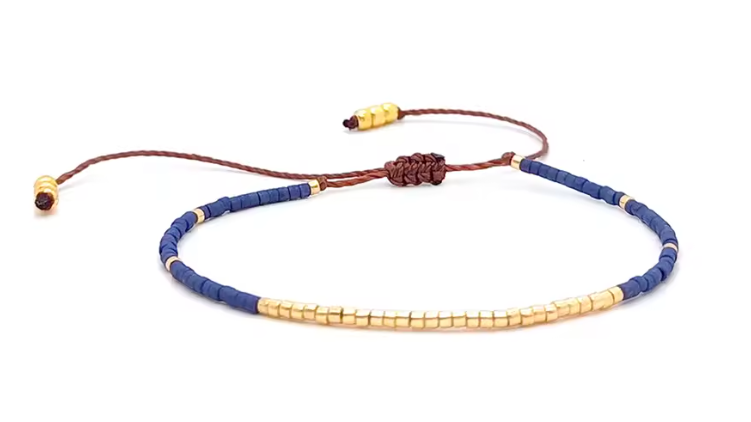 Bracelet with blue and gold beads on a white background