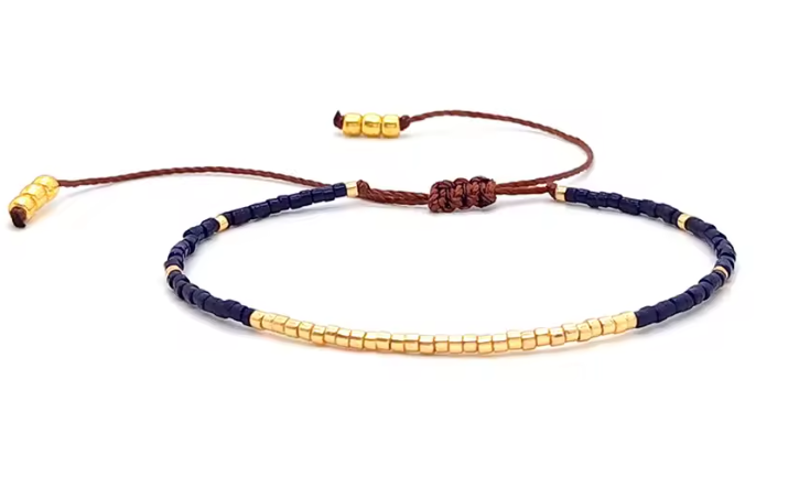 Navy and gold beaded bracelet on a white background