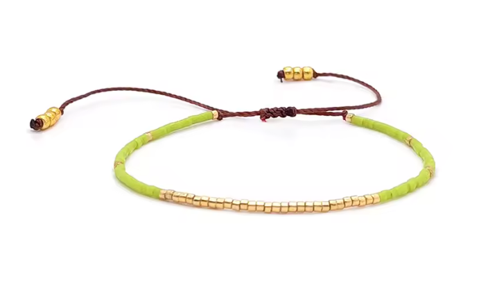 Necklace with green beads and gold accents on a white background
