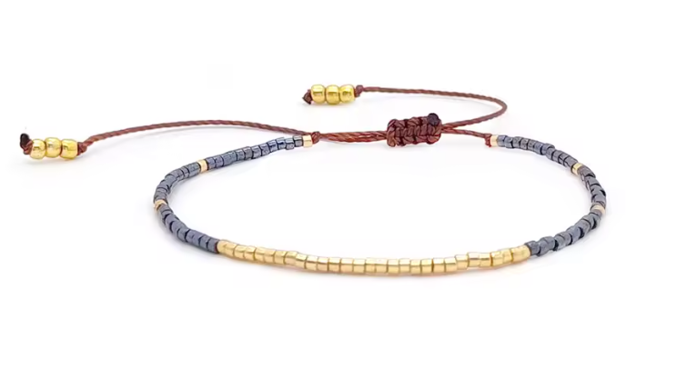 Bracelet with gold and gray beads on a white background