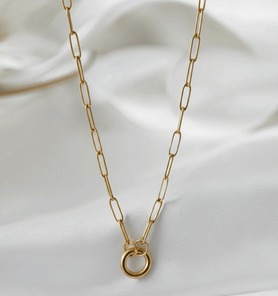 Gold chain necklace on a white fabric background