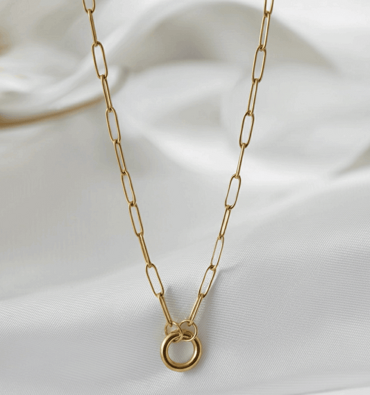 Gold chain necklace on a white fabric background