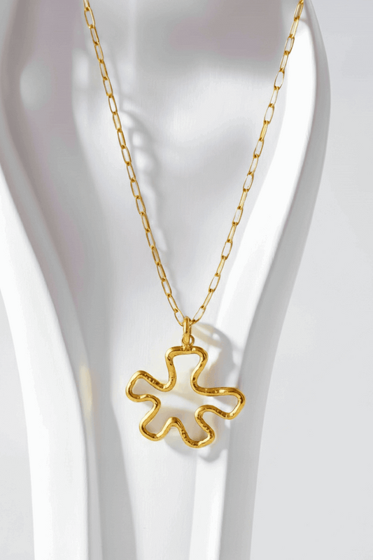 Gold necklace with a unique pendant on a white background
