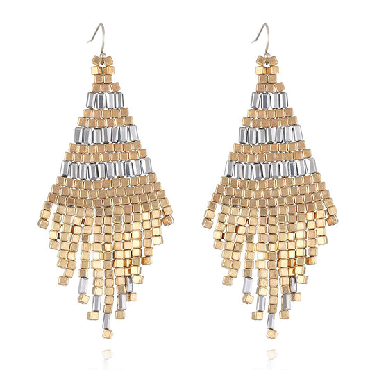 Pair of gold and silver beaded earrings on a white background