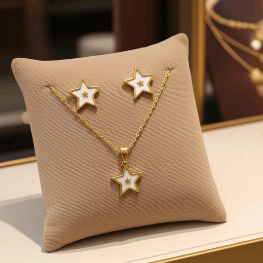 Star-shaped gold necklace and earrings set on a beige pillow