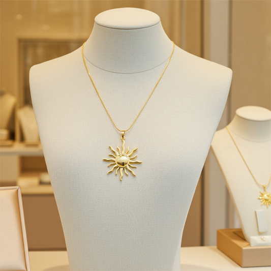 Gold necklace with a sun pendant on a mannequin bust in a jewelry store setting.